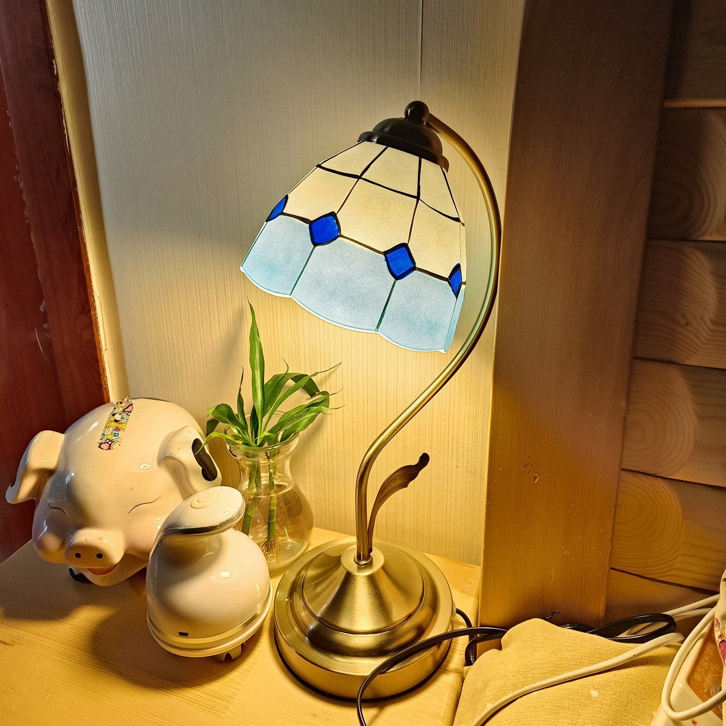 EleganceBloom – Guld bordlampe med hvid og blå glasblomst